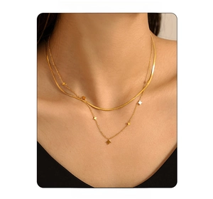 Nahaufnahme der zweilagigen goldenen Schlangenkette mit funkelnden Sternanhängern am Model