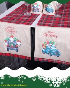 Détail d'un chemin de table de Noël avec motif à carreaux, camion bleu et Père Noël