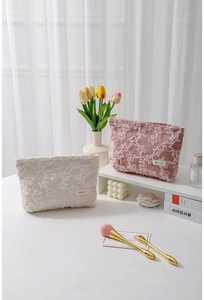Detailed texture of corduroy lace cosmetic bags in cream and rose pink with floral embroidery