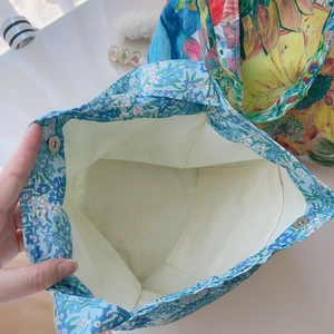 Detailed interior of a floral canvas tote bag featuring magnetic closure and inner pocket
