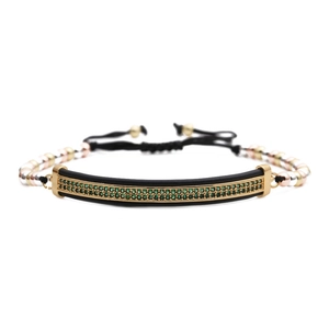 Détail macro du bracelet perlé ajustable avec barre en métal noir sertie de cristaux verts