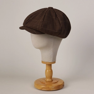 Close-up of retro brown checkered octagonal newsboy hat on a wooden mannequin stand