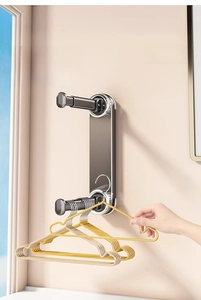 Detail of retractable wall-mounted laundry rack with suction cups and yellow hangers