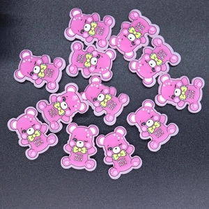 Macro detail of pink bear DIY charms with HUG ME text for craft accessories