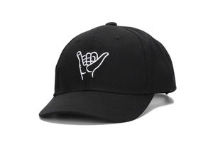 Close-up of a black cotton baseball cap featuring a white Shaka hand gesture embroidery
