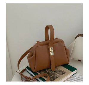 Retro brown leather doctor bag with gold clasp hardware on vintage book props