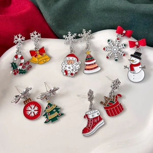 Weihnachtsohrringe Set mit Weihnachtsmann, Baum und Rentier auf weißem Keramikteller