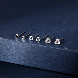 Macro detail of three pairs of S925 sterling silver heart stud earrings with cubic zirconia