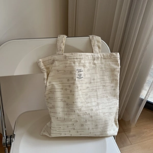 Minimalist cream textured cotton linen tote bag on a white folding chair in a soft room