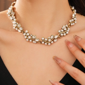 Close-up of vintage pearl necklace with gold vine base and shimmering rhinestones on neck
