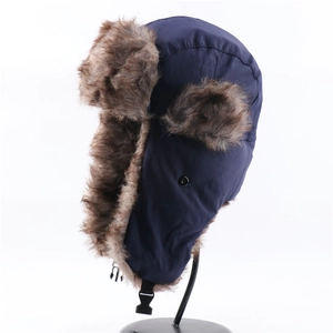 Detail view of winter trapper hat with navy windproof shell and brown faux fur lining