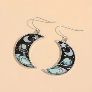 Macro detail of crescent moon earrings featuring celestial galaxy patterns on metal hooks