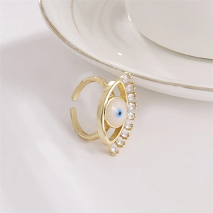 Verstellbarer Evil Eye Ring mit Goldfinish und Zirkonia-Steinen auf weißem Untergrund