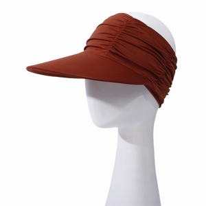Close-up of caramel sun visor hat with pleated elastic band and wide brim detail