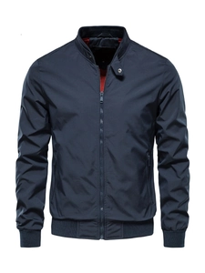 Detail of navy bomber jacket featuring orange lining and ribbed cuffs with metal snaps