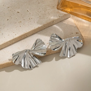 Detailed macro shot of silver ginkgo leaf earrings with unique textured metallic finish