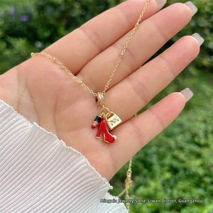 Dettaglio della collana placcata oro 18K con ciondoli a scarpa, rossetto e borsa