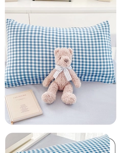 Blue and white checkered pillowcase paired with a cute brown teddy bear on a bed