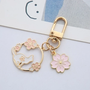 Japanese style gold cherry blossom keychain with white cat silhouette and pink flower charm