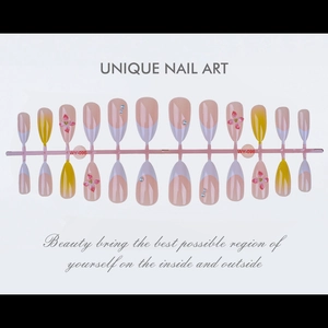 Detail of almond nails with 3D floral patterns, yellow accents, and pearl embellishments