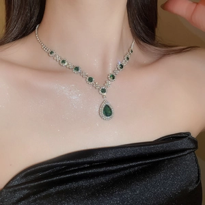 Close-up of luxury water-drop emerald pendant necklace with pavé zircon settings
