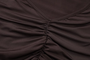 Detail of V-neckline and ruched texture on dark coffee brown elastic knit fabric