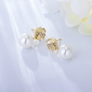 Macro shot of gold flower earrings featuring cubic zirconia and elegant white pearls