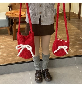 Detail of red plush bucket bags in two sizes with white bows and soft faux fur texture