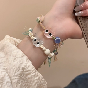 Detailed view of handmade ceramic kitten bracelets with colorful beads and woven strings