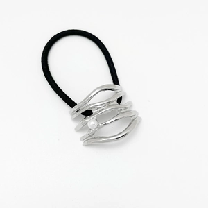 Detail of silver wavy alloy hair tie with white pearl on black elastic band