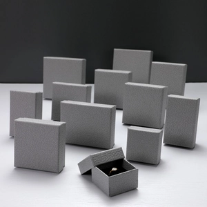 Detail of grey litchi grain leather jewelry boxes with a gold ring inside