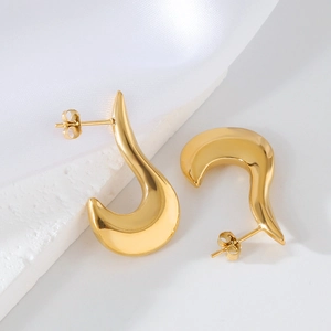 Vue macro de boucles d'oreilles croissant en forme de U en acier inoxydable doré