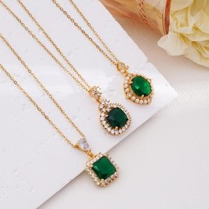 Three gold necklaces with emerald green pendants in square, pear and oval shapes