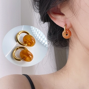 Detail of 18k gold plated hoop earrings with amber resin pendant and model view