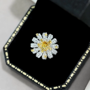 Macro view of sunflower ring with yellow center stone and pavé petals on black background