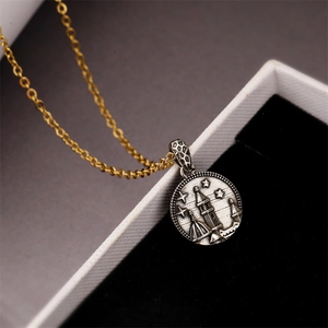 Detail of two-tone punk necklace with silver round pendant and castle engraving