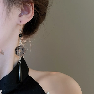Detail view of long ink-wash style earrings with Chinese calligraphy and water drop pendants