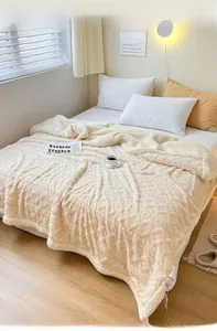 Detail of creamy white thickened fleece blanket with textured square grid pattern weave