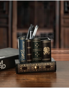 Détail d'un porte-stylo rétro en forme de livres avec quatre fentes et un petit tiroir