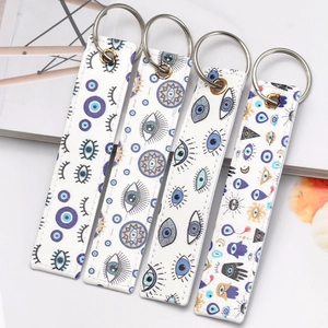 Detail of four faux leather Evil Eye rectangular keychains with silver metal rings