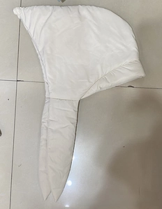 Flat lay detail of white quilted down cotton hood showing padded material and stitching
