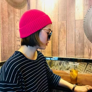 Solid neon pink ribbed knit beanie hat for winter warmth shown on a model
