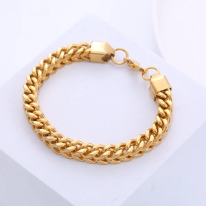 Mens 8mm gold stainless steel Franco chain bracelet displayed on white platform