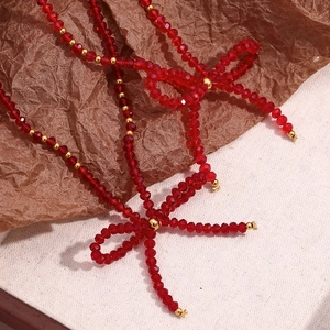 Elegant red faceted crystal and gold bead necklace with stylish bow pendant design