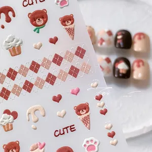 Detail of 5D embossed bear and cupcake nail stickers with a textured 3D relief finish