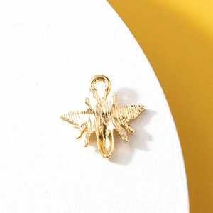 Golden 3D bee pendant with textured details on a white circular display stand