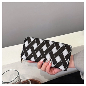 Detail of classic black and white diagonal woven pattern with golden zipper on a wallet