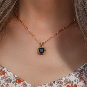 Gold paperclip chain necklace featuring a square blue zircon pendant worn on neck