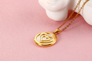 Macro view of gold stainless steel double heart pendant with white shell inlay