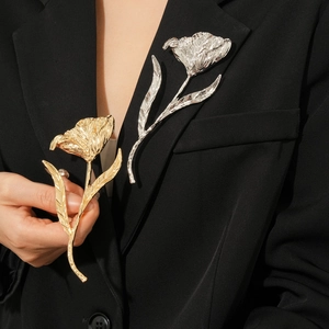 Detailed view of large gold and silver metal tulip brooches with elegant wrinkled texture